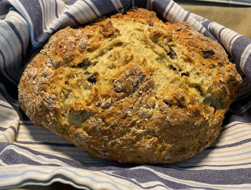 Home-made Irish soda bread fresh from the oven and wrapped in a kitchen cloth.