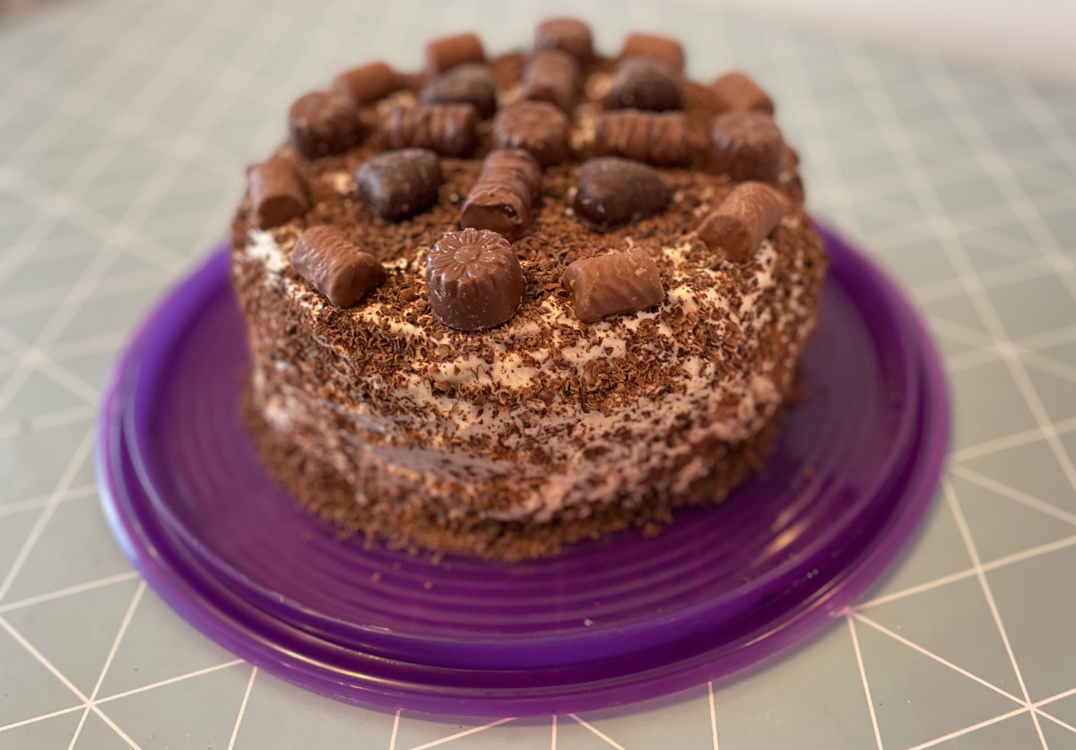 Chocolate cake with caramel filling and topping and confectionary decorations.