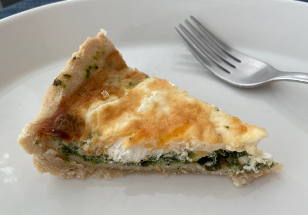 A piece of spinach and feta cheese pie on a plate. 